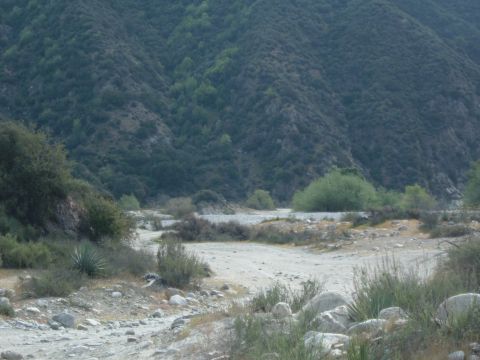 1988 Ford Bronco - A dry riverbed winds through a mountainous, brush-covered landscape.