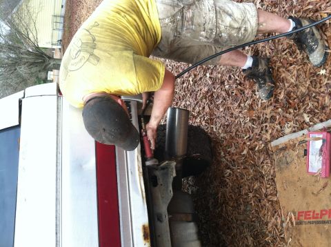 1992 Ford C-350 (Centurion Conversions) - Man welding exhaust pipe on a 1992 Ford C-350 (Centurion Conversions).