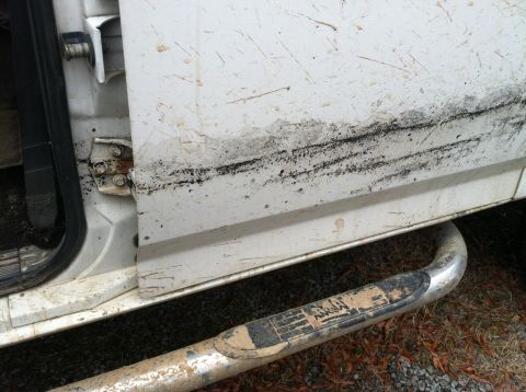 1992 Ford C-350 (Centurion Conversions) - Close-up of a dirty truck door and running board, showing wear and tear.