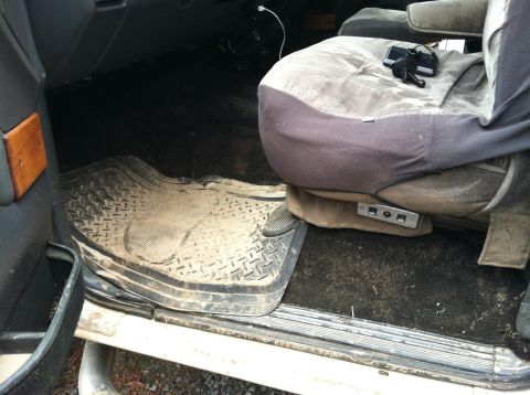 1992 Ford C-350 (Centurion Conversions) - The interior of the vehicle shows heavy wear and tear, with dirty floor mats and seat covers.