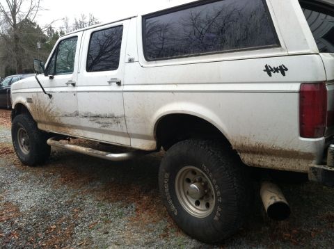 1992 Ford C-350 (Centurion Conversions) - This white 1992 Ford C-350 Centurion Conversions SUV shows significant mud splatter and damage along its side.