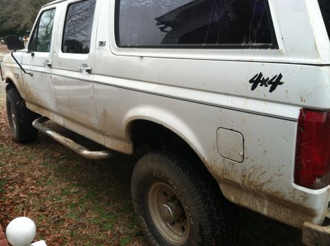 1992 Ford C-350 (Centurion Conversions) - This white SUV has a "4x4" decal on its side and is covered in mud.