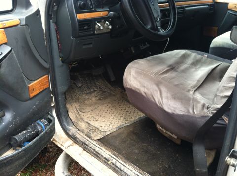 1992 Ford C-350 (Centurion Conversions) - The interior of a 1992 Ford C-350 (Centurion Conversions) shows signs of wear and tear, with diamond plate floor mats and wood trim accents.