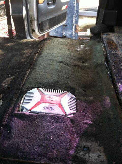 1992 Ford C-350 (Centurion Conversions) - A 480W car amplifier is visible in the carpeted floor of a vehicle's interior.