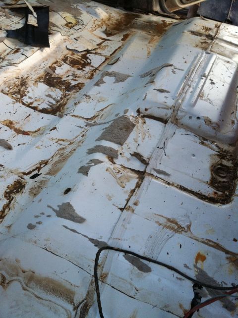 1992 Ford C-350 (Centurion Conversions) - The interior floor of a vehicle shows significant dirt, rust, and damage, suggesting a difficult past.
