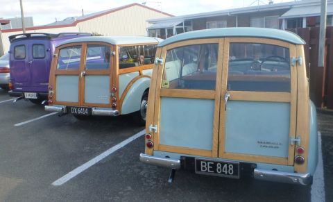 1969 MINI Cooper - Rear view of two classic woodie station wagons, one with license plate BE 848.