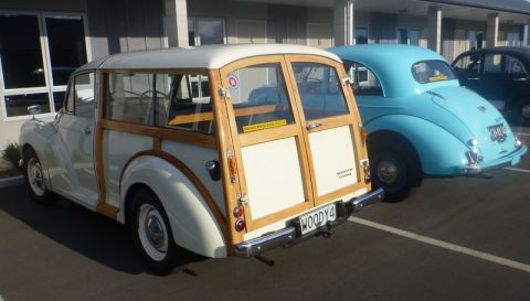 1969 MINI Cooper - A classic woodie station wagon is parked next to a blue car, with another dark car in the background.