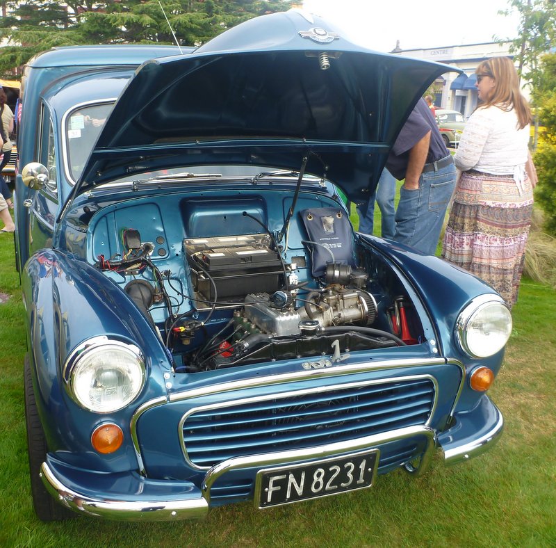 Blue van, hood open, revealing engine and battery. License plate FN 8231