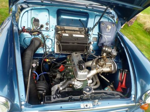 1969 MINI Cooper - The engine compartment of a vintage automobile is displayed, revealing its mechanical components and wiring.