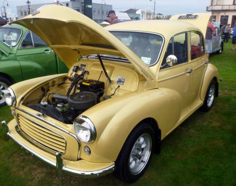 1969 MINI Cooper - A yellow sedan with its hood and trunk open is displayed on a grassy field at an outdoor event.