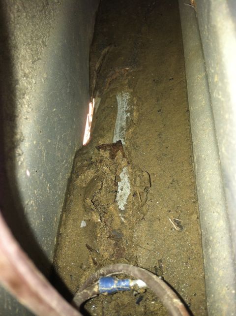 1992 Ford C-350 (Centurion Conversions) - Close-up of accumulated dirt and debris within a vehicle's structural components.