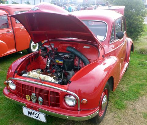 1969 MINI Cooper - A classic red car with its hood open is displayed outdoors, with another vehicle nearby.