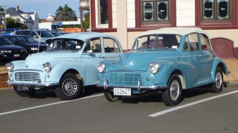1969 MINI Cooper - Two Morris Minors, a classic British car model, are parked in a lot.