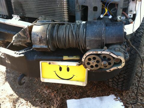 1992 Ford C-350 (Centurion Conversions) - A winch is mounted to the front bumper, with exposed gears and a smiley face license plate.