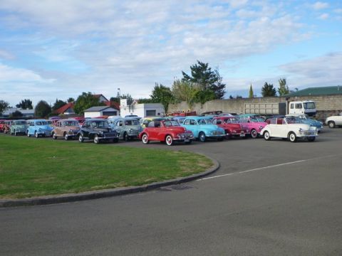 1969 MINI Cooper - A collection of vintage automobiles are gathered together in an outdoor lot under a cloudy sky.