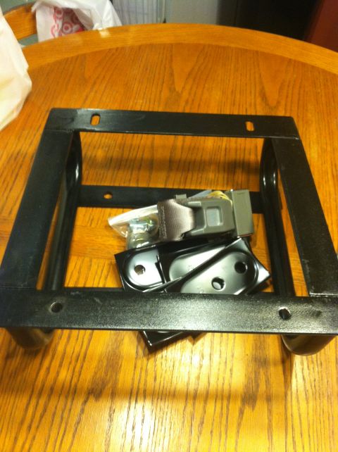 1992 Ford C-350 (Centurion Conversions) - Seat belt and mounting hardware are displayed on a wooden table.