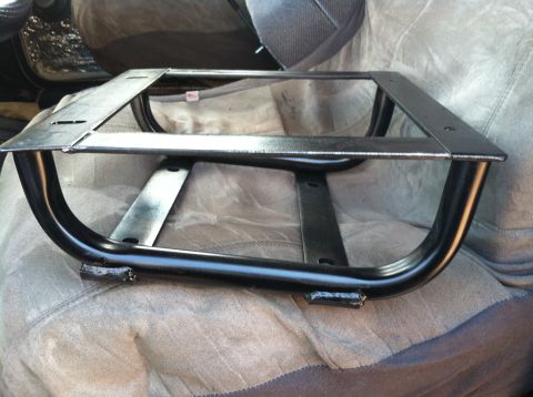 1992 Ford C-350 (Centurion Conversions) - A custom metal bracket is shown resting on a vehicle's seat cover.