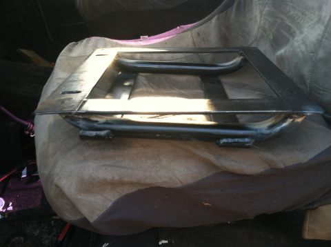 1992 Ford C-350 (Centurion Conversions) - A metal seat frame rests on a blanket, likely inside a vehicle's interior.