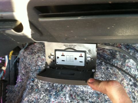 1992 Ford C-350 (Centurion Conversions) - An aftermarket electrical outlet is installed in a vehicle's interior, with exposed insulation and wiring visible.