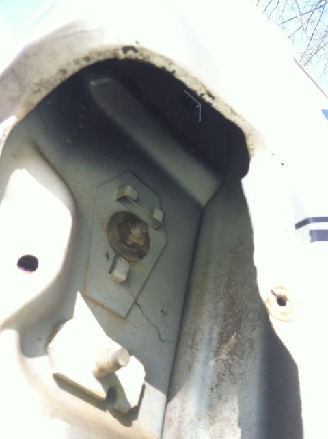 1992 Ford C-350 (Centurion Conversions) - A close-up view of a rusty metal bracket and bolt, showing signs of wear and tear.