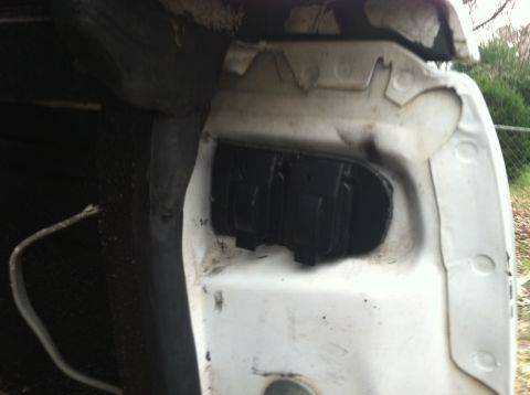 1992 Ford C-350 (Centurion Conversions) - The rear of a white vehicle, with the tail light housing exposed and empty.
