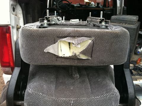 1992 Ford C-350 (Centurion Conversions) - A torn truck seat shows exposed foam and damaged upholstery, indicating significant wear or damage.