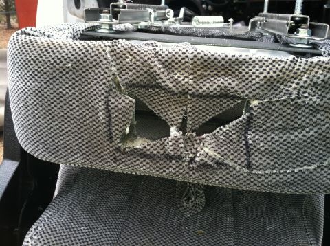 1992 Ford C-350 (Centurion Conversions) - Close-up of damaged seat upholstery, revealing exposed foam and metal seat frame components.