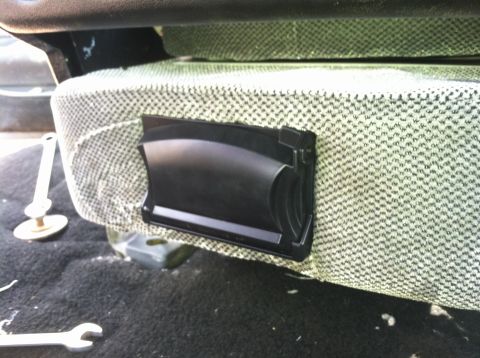 1992 Ford C-350 (Centurion Conversions) - A black plastic trim piece is attached to the side of a seat, with tools visible on the floor.
