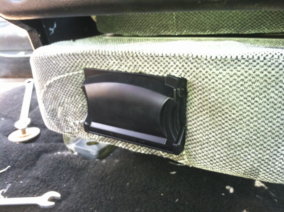 Close-up of a black plastic interior trim piece attached to a seat