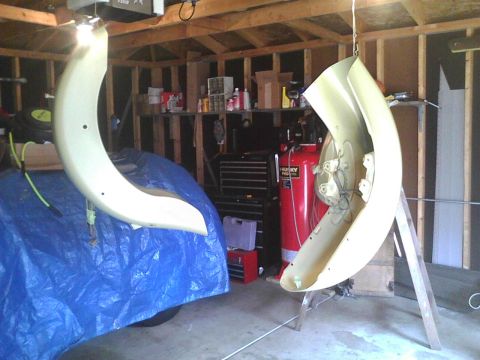 2003 Ford Crown Victoria - Car fender parts are suspended in a garage, awaiting work or installation.