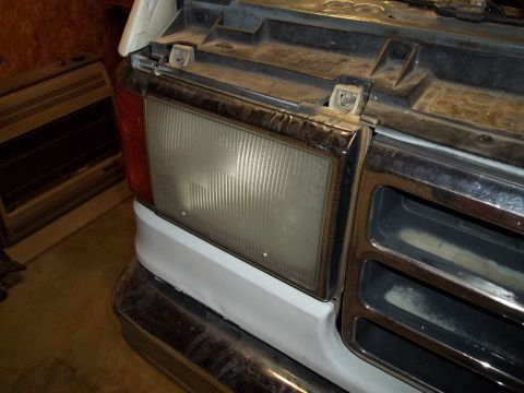 1990 Ford Bronco - Close-up of the front end of a 1987 Ford Bronco, showing the headlight and grille detail.