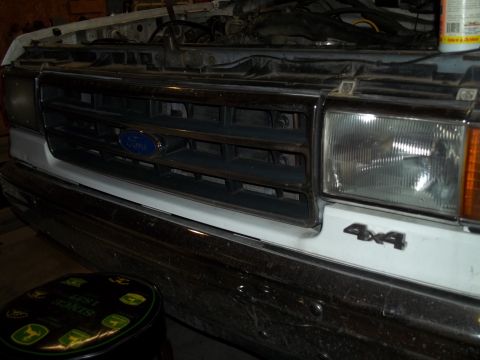 1990 Ford Bronco - Close-up of a Ford truck's front grille and headlights, showing the '4x4' badging.