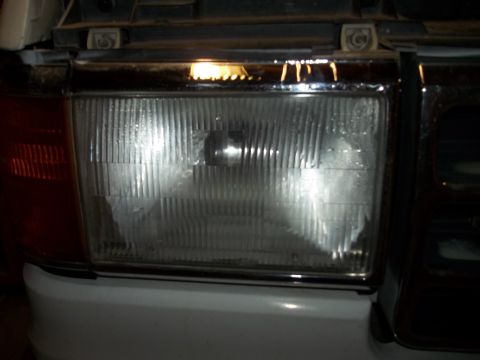 1990 Ford Bronco - Close-up of a 1990 Ford Bronco's front headlight and grille detail.