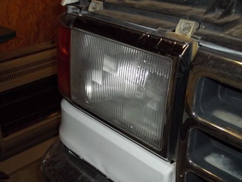 1990 Ford Bronco - Close-up of the front headlight and grille assembly on a 1990 Ford Bronco.