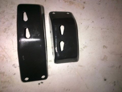 1994 Ford Bronco - Two black metal brackets with slotted holes are shown against a light-colored surface.
