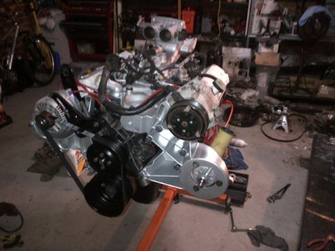 1994 Ford Bronco - Engine assembly on an orange stand in a garage setting.