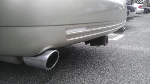 2000 Mercury Grand Marquis - Rear view of a silver Mercury Grand Marquis showing its bumper, exhaust, and trailer hitch.