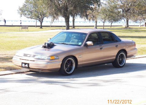 1993 Ford Crown Victoria - This 1993 Ford Crown Victoria has a prominent hood scoop and custom wheels.