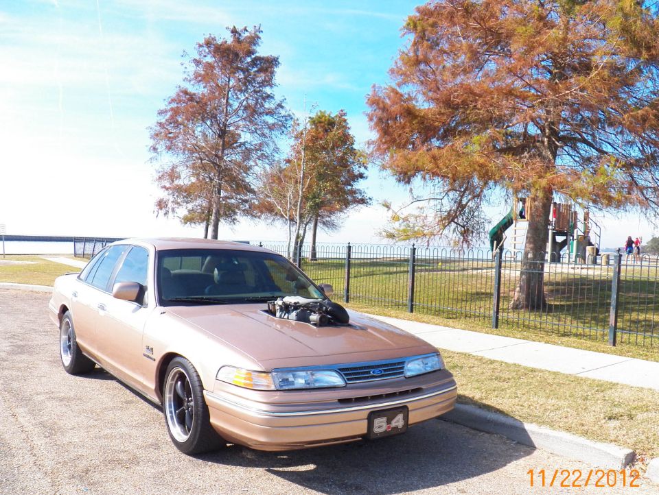 1993 Ford Crown Victoria with engine exposed through hood, parked roadside