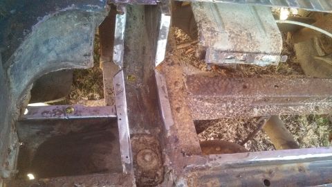 1979 Ford Bronco - Close-up view of heavily rusted vehicle frame components and structural supports.