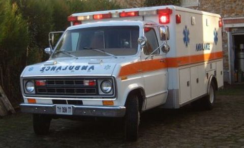 1991 Ford Crown Victoria - This ambulance has "AMBULANCE" written on the side and a distinctive orange stripe along its body.