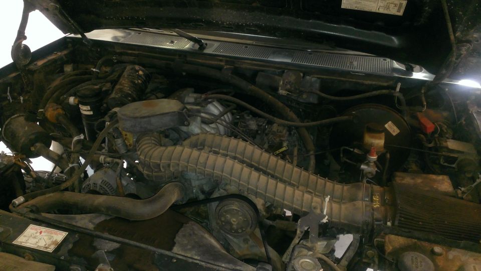 Engine bay with hoses, wires, and engine components visible. Watermark for Supermotors.net
