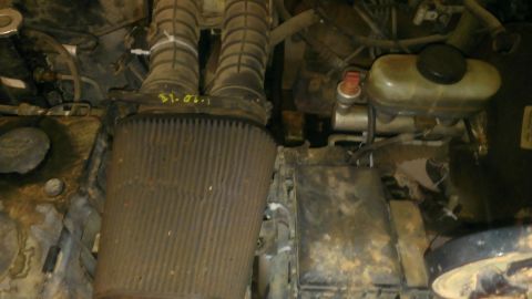 1994 Ford Bronco - Close-up view of an engine bay, showing air intake components and a brake fluid reservoir.