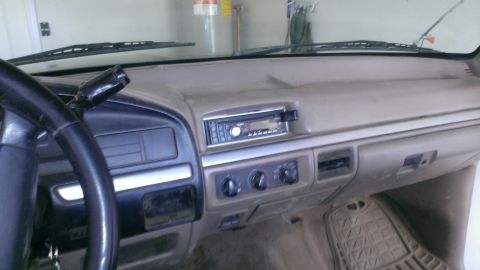 1994 Ford Bronco - The interior of a truck's dashboard is visible, including the steering wheel, radio, and climate controls.