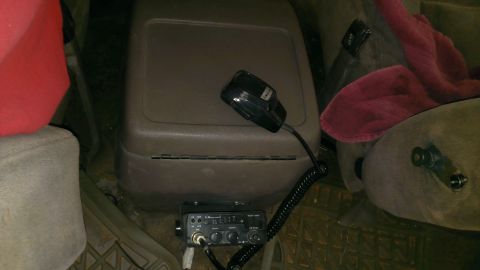 1994 Ford Bronco - A CB radio and microphone are mounted in the center console of a vehicle, with seats visible on either side.