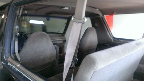 1994 Ford Bronco - The interior of a 1994 Ford Bronco is visible, with a focus on the front seats and dashboard area.