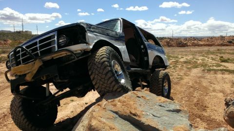 1994 Ford Bronco - This modified 1994 Ford Bronco is shown navigating a rocky terrain with its doors open.