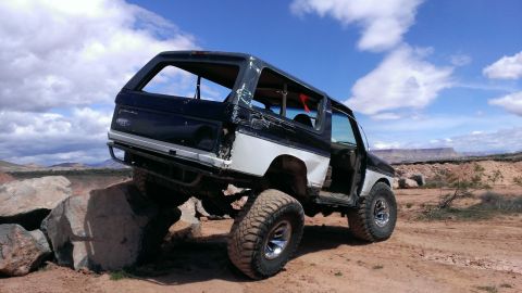 1994 Ford Bronco - Modified Ford Bronco navigates a rocky terrain under a cloudy sky.