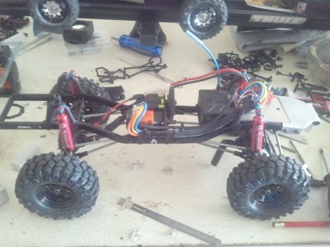 1985 Ford Bronco - RC car chassis assembly with suspension components and electrical wiring visible.