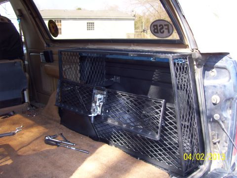 1990 Ford Bronco - The rear storage compartment of a 1990 Ford Bronco features a custom metal cage and shelving.